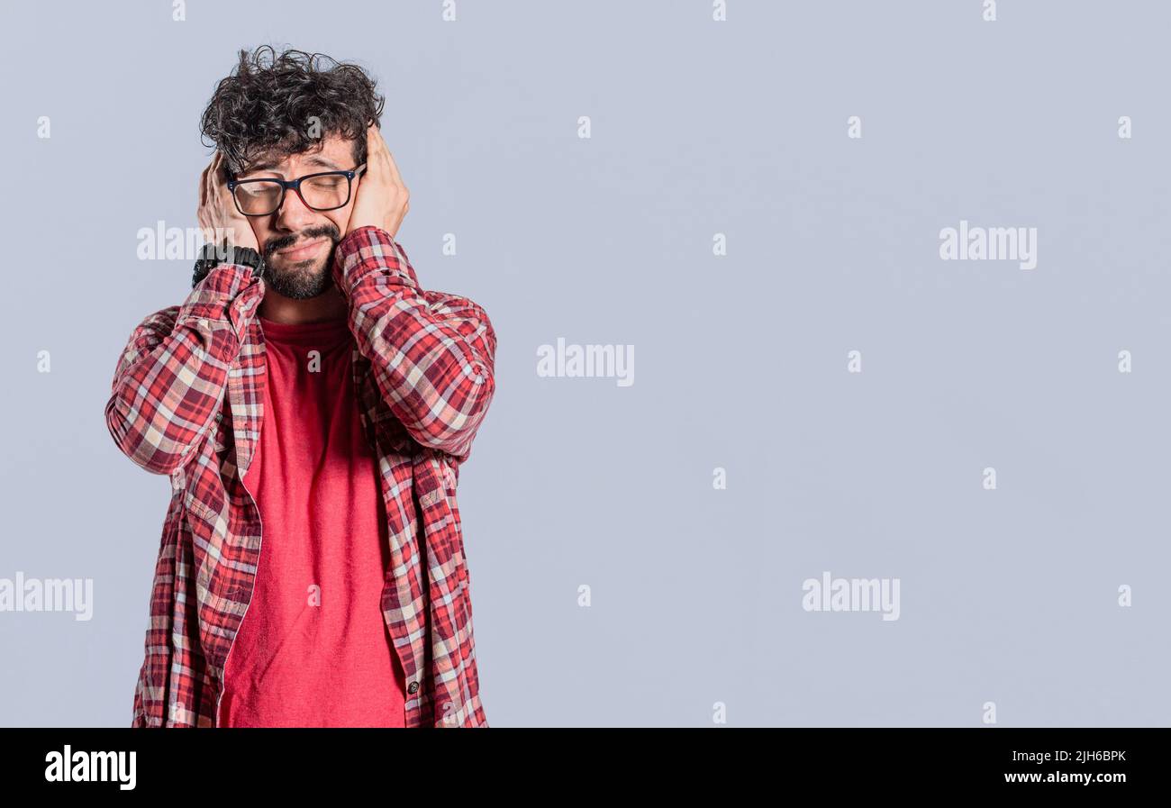 Desperate man covering his ears on isolated background, Desperate person covering his ears, avoiding hearing, deaf ears concept Stock Photo