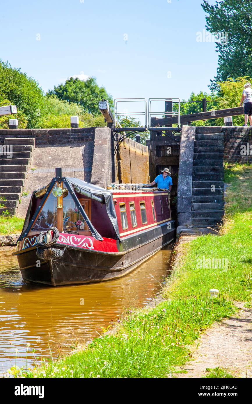 Man and woman on a canal narrowboat holiday after passing through lock 65 Wheelock top lock, on the Trent and Mersey canal at Wheelock Cheshire Stock Photo