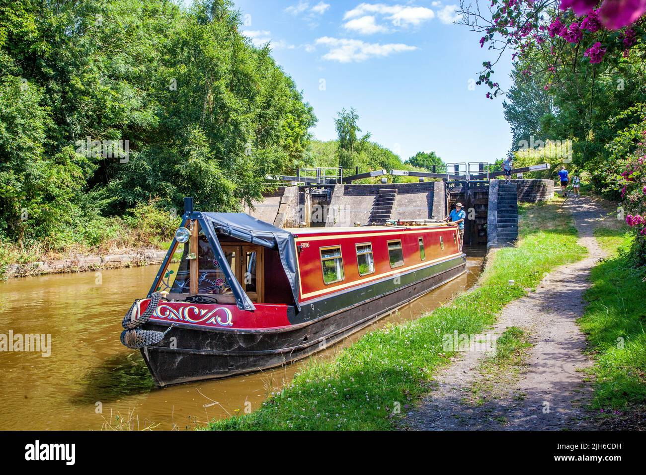 Man and woman on a canal narrowboat holiday after passing through lock 65 Wheelock top lock, on the Trent and Mersey canal at Wheelock Cheshire Stock Photo
