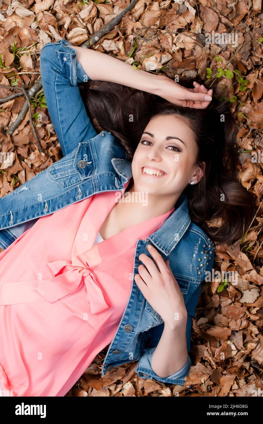 Young woman lying on the forest floor Stock Photo - Alamy