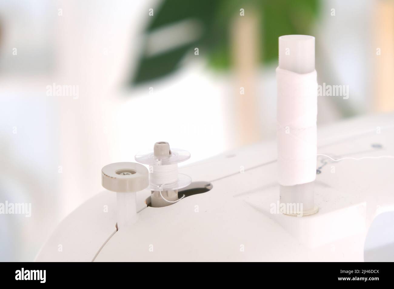 Winding threads on a bobbin on a sewing machine Stock Photo Alamy