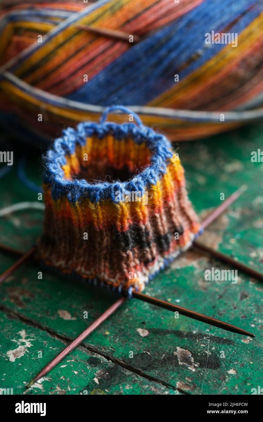 Handwork, knitted sock with knitting needles and wool Stock Photo - Alamy