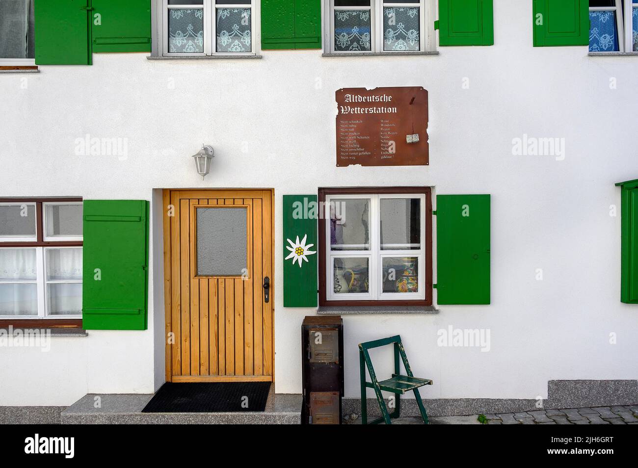 Facade with green shutters and persiflage Old German weather station, Nesselwang, Allgaeu, Bavaria, Germany Stock Photo