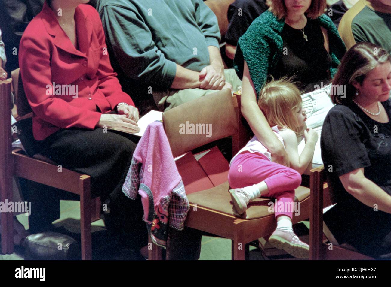 A young girl lays down in her seat during a memorial and prayer service to Diana, the Princess of Wales, on the occasion of her death at the Washington National Cathedral, September 6, 1997, in Washington, D.C. Stock Photo