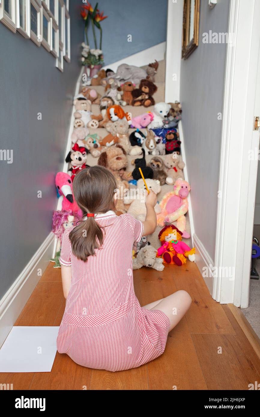young girl playing with toys in hallway Stock Photo