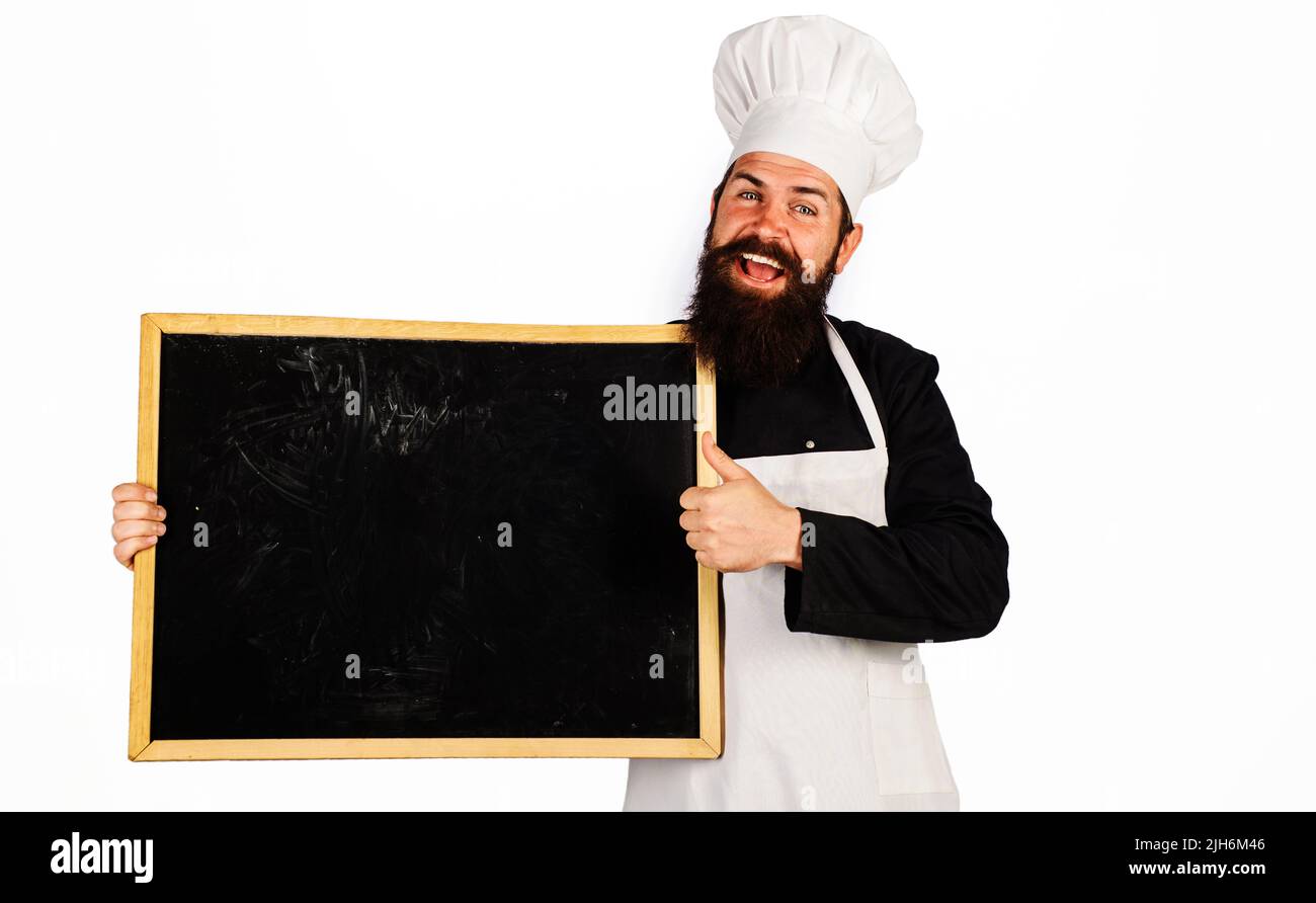 Smiling chef, cook or baker with blackboard shows thumb up. Cooking, advertisement and food concept. Stock Photo