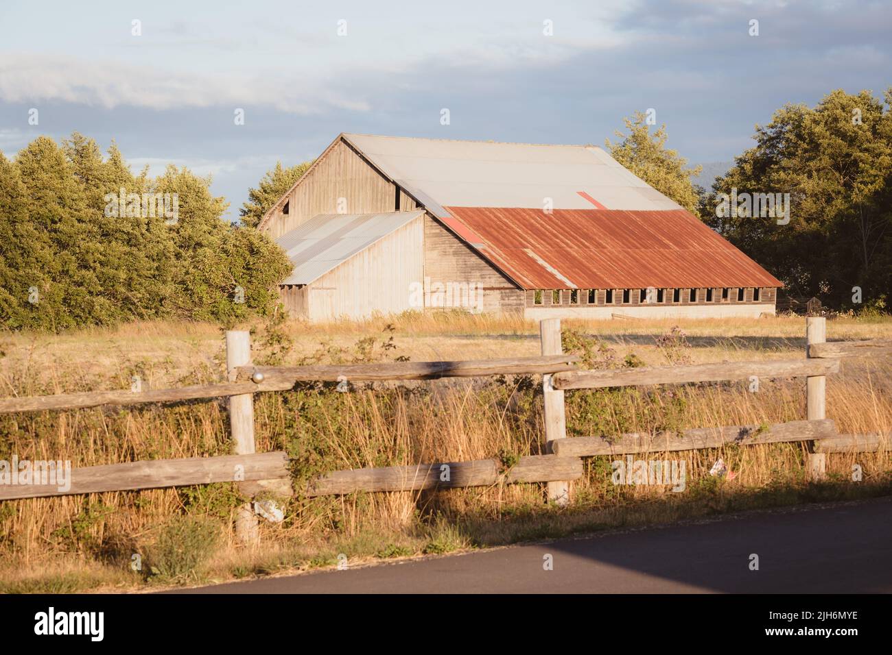 Rustic Barn on Farm with Wooden Fence Stock Photo