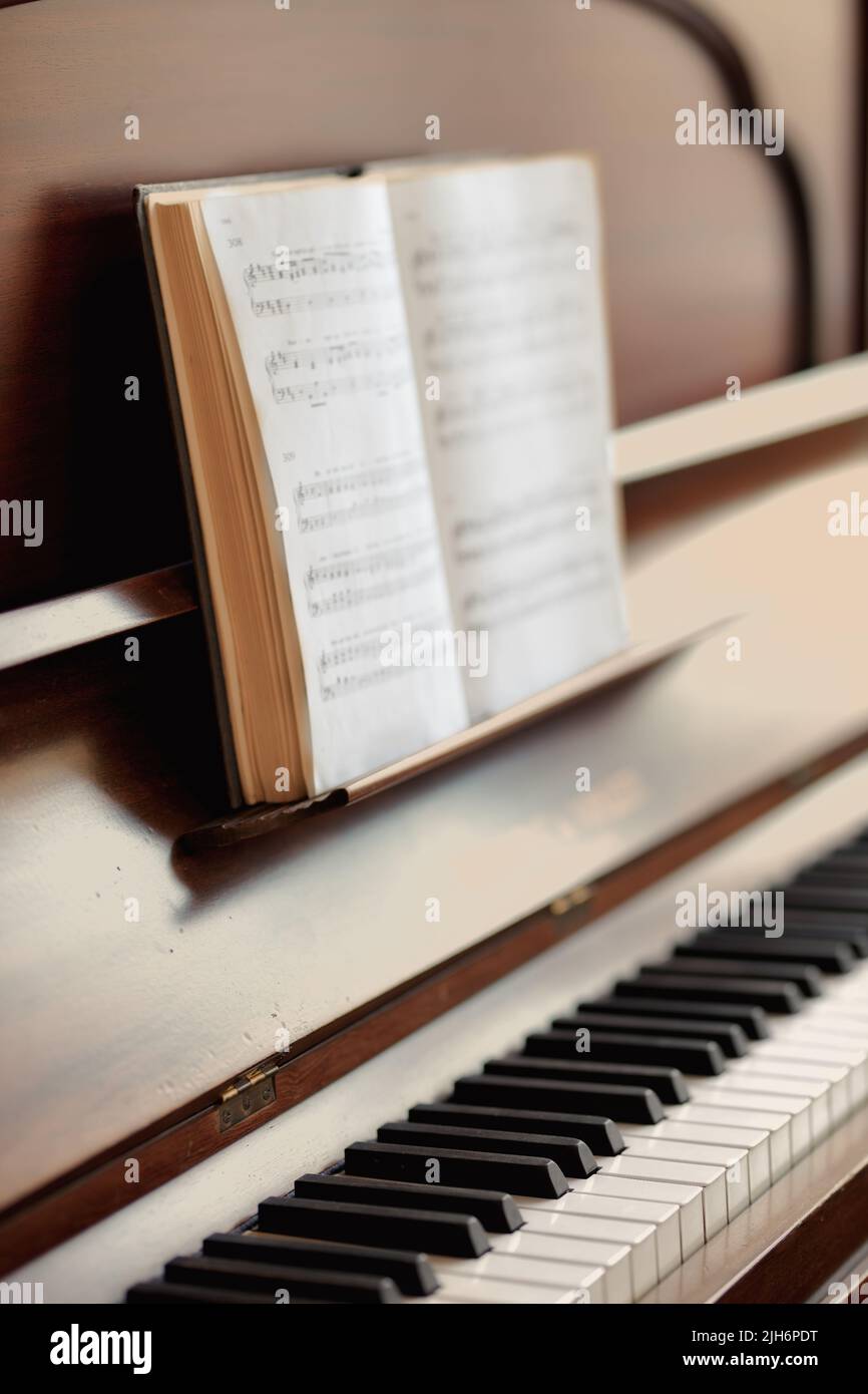 Closeup of a vintage piano and keyboard with a sheet music book. An empty  antique or wooden musical instrument for playing classical jazz or used for  Stock Photo - Alamy