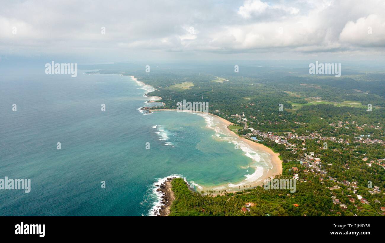 The coast with a beach and hotels among palm trees. Dickwella Beach, Sri Lanka. Stock Photo