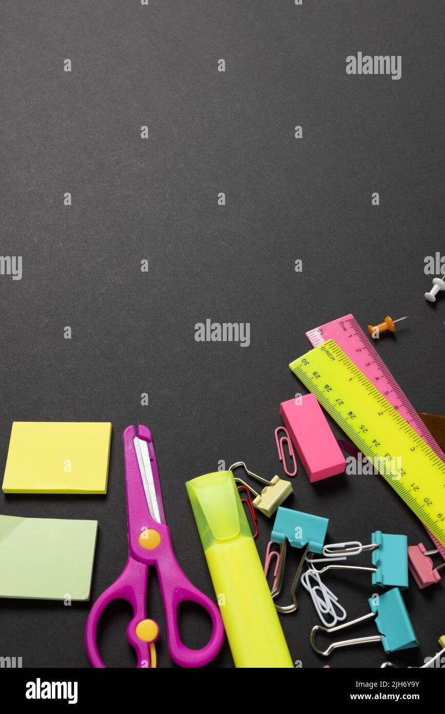 Imagine of various office supplies, pins, rulers, scissorson on black