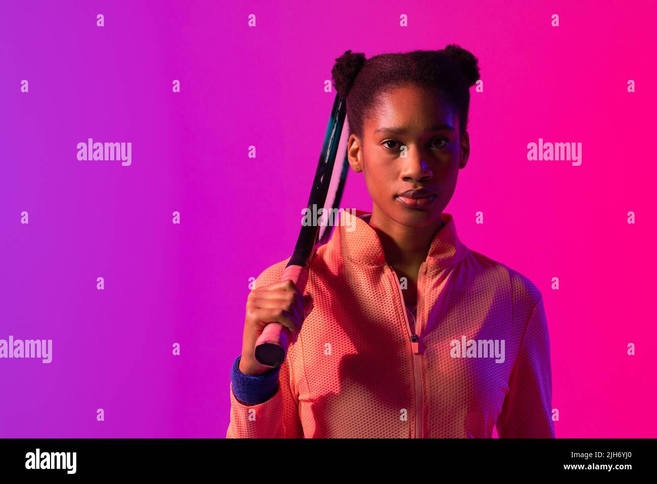 Image of african american female tennis player in violet and pink neon lighting Stock Photo