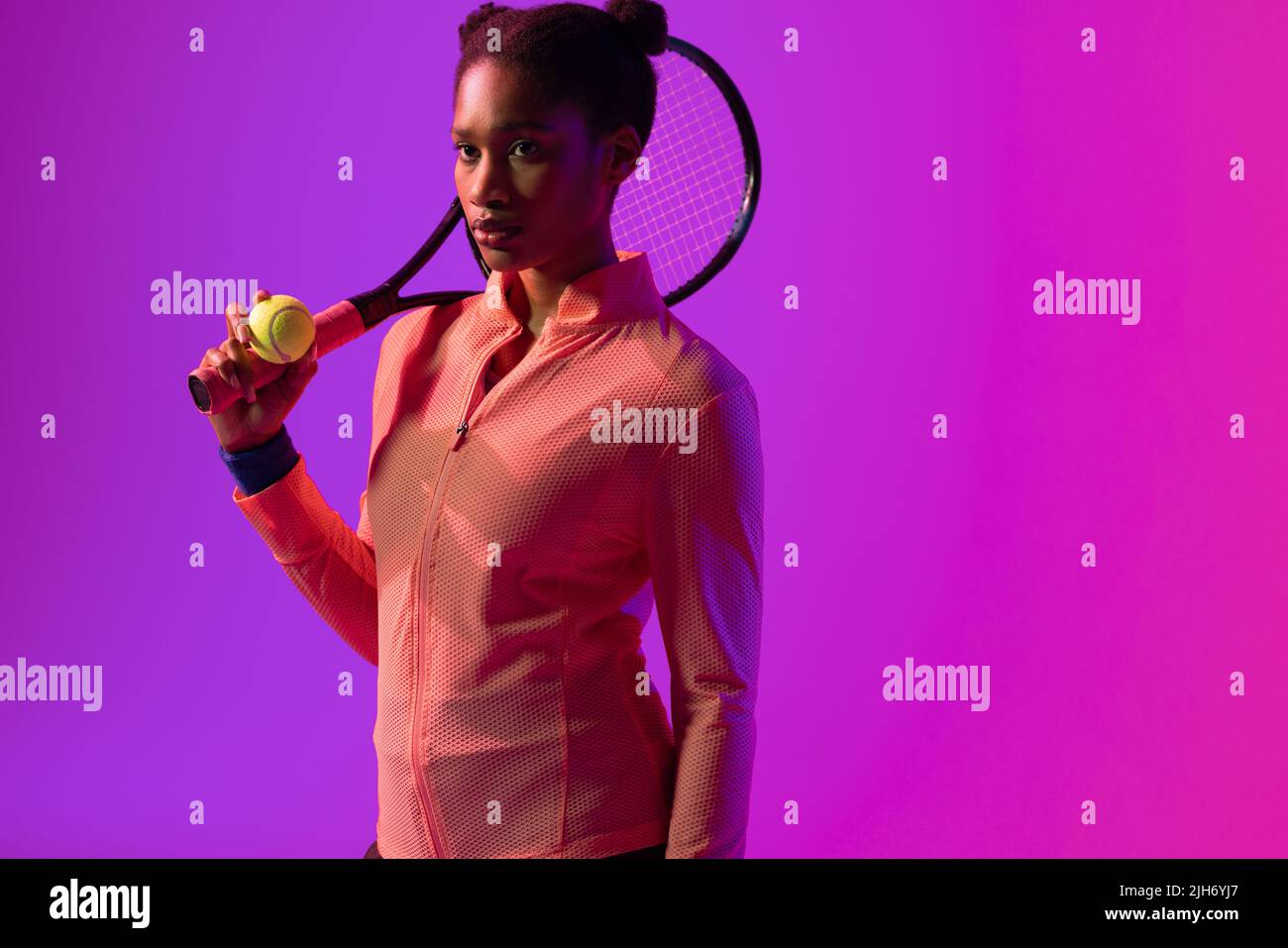 Image of african american female tennis player in violet and pink neon lighting Stock Photo