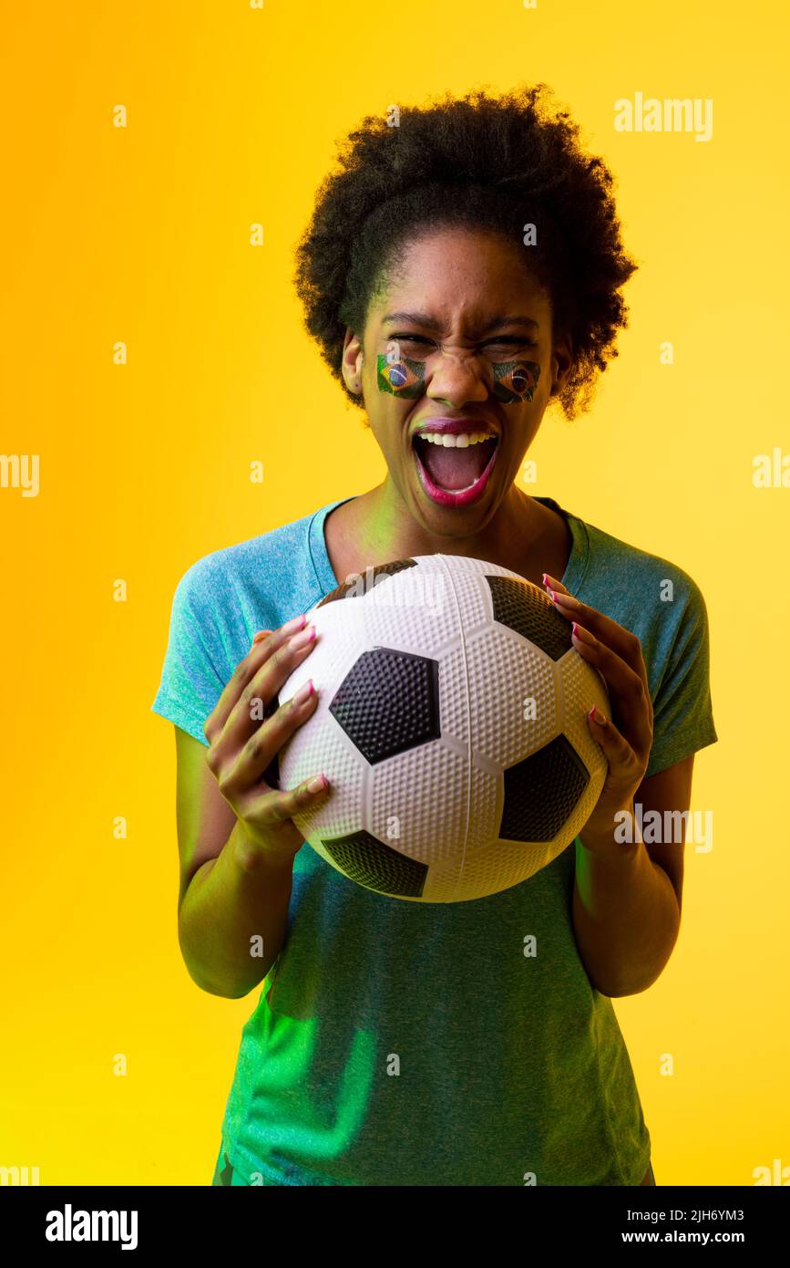 Vertical image of african american female soccer fan with flag of