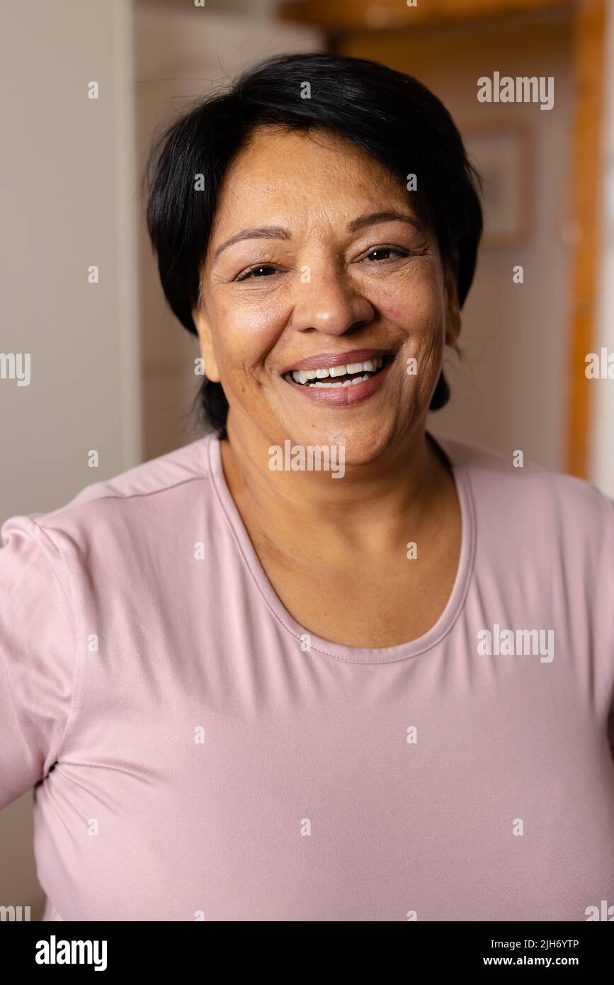 Close-up portrait of happy biracial mature woman with short hair laughing at home Stock Photo