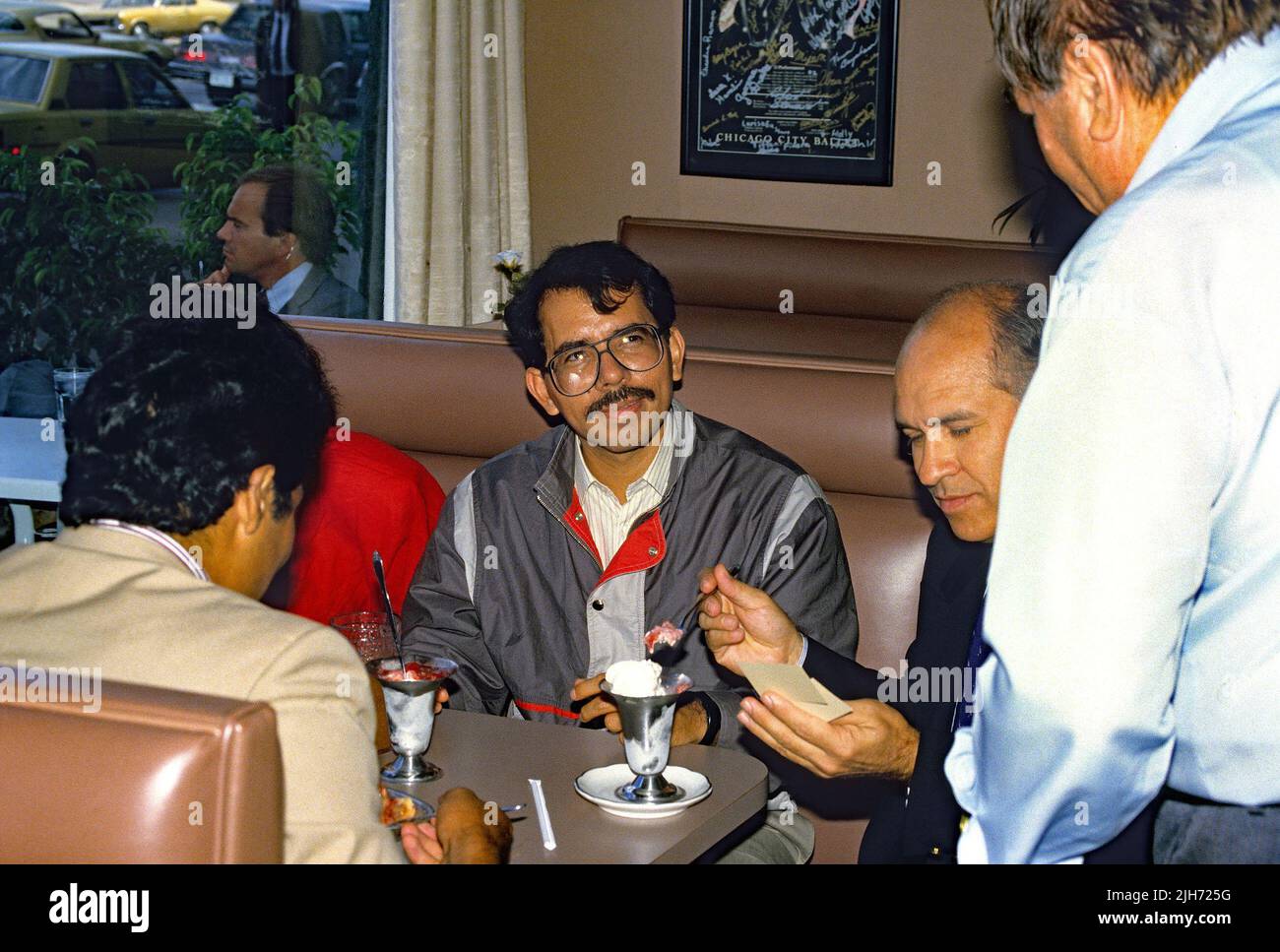 CHICAGO, ILLINOIS - AUGUST 2, 1986 President of Nicaragua Daniel Ortega sits with his family enjoying some of Chicago's famous hot dogs, followed by ice cream sundaes at diner on Michigan Avenue after meeting with the Rev. Jesse Jackson at PUSH headquarters. Credit: Mark Reinstein / MediaPunch Stock Photo