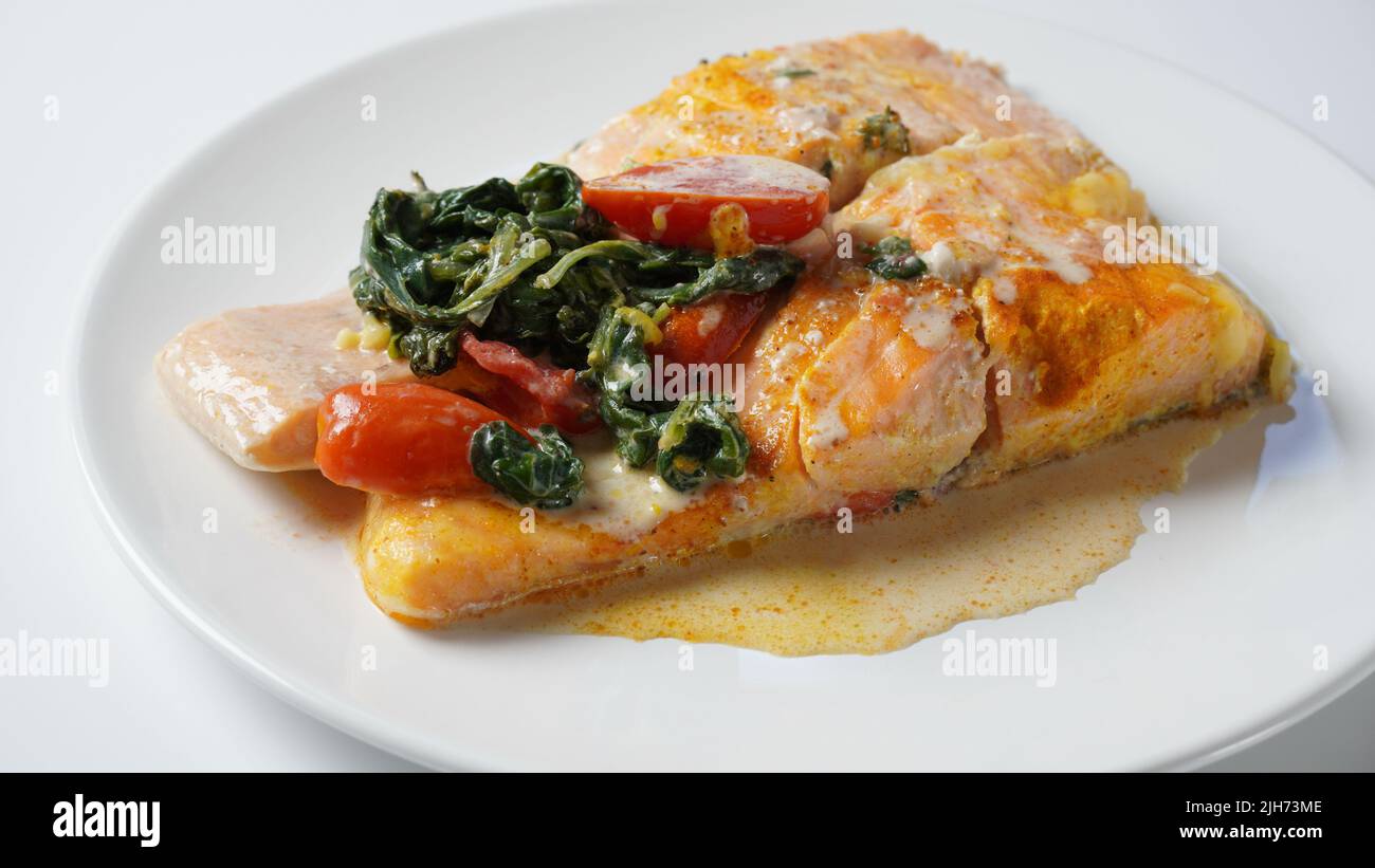 Salmon Fillet with spinach and cherry tomatoes in creamy sauce Stock