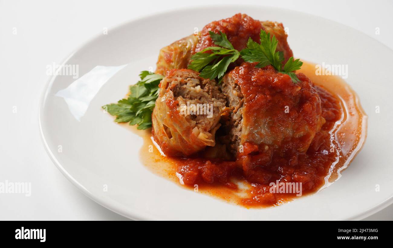 Stuffed cabbage rolls with tomato sauce and herbs Stock Photo