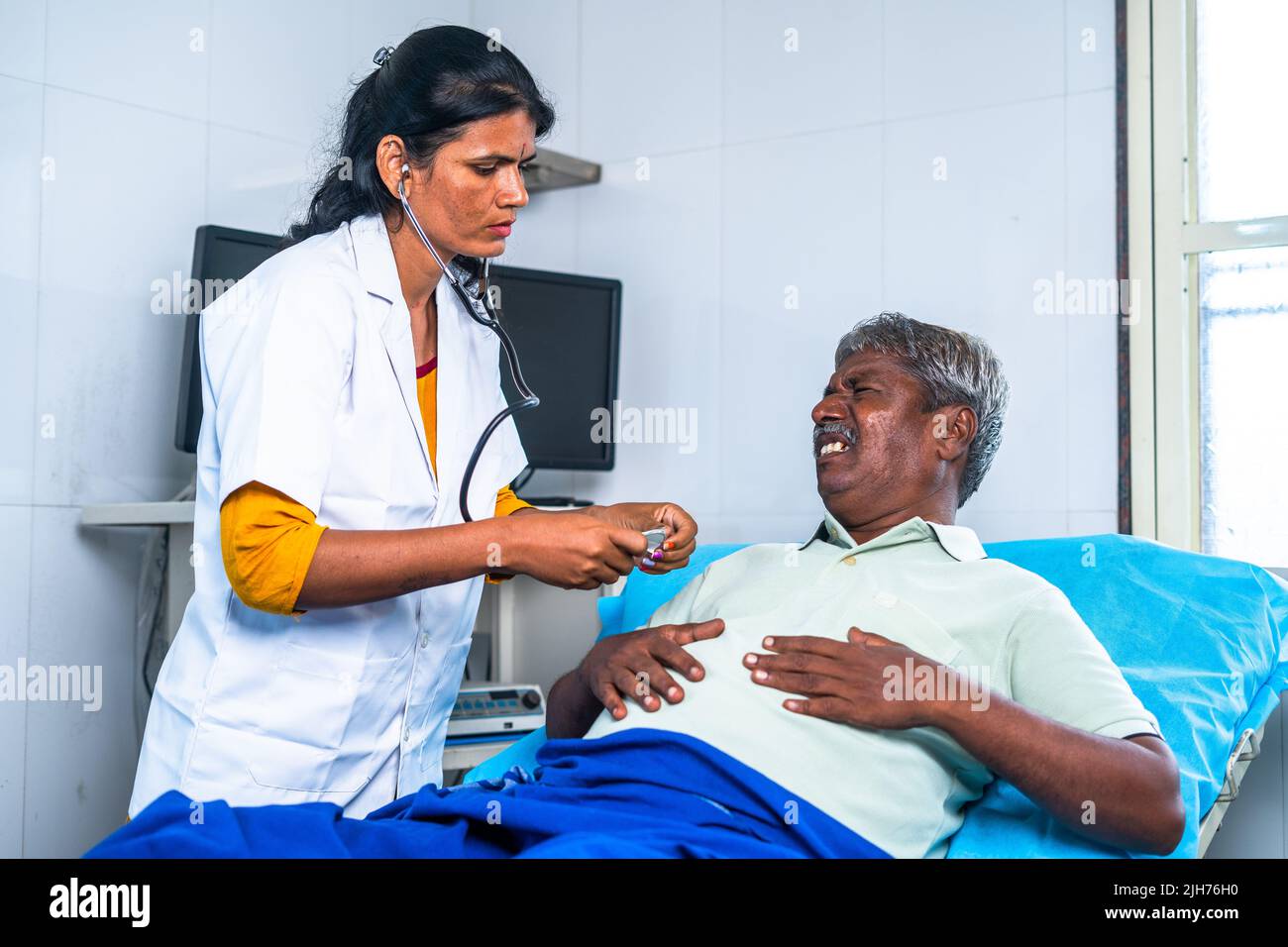 Doctor checking suffering senior man chest pain at hospital ward - concept of health care treatment , cardiac arrest and professional occupation Stock Photo