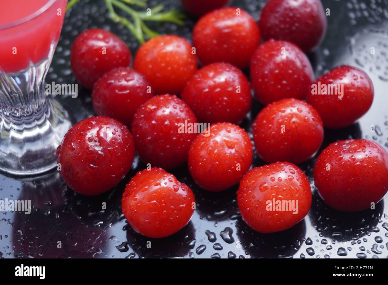 Cherry fruit on a black background with water drops - a beautiful background with organic food. Stock Photo