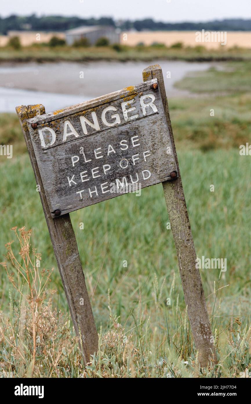 PITSEA, essex, uk - JULY 12, 2022:  Old wooden danger sign on a creek in warning people to keep off the mud Stock Photo