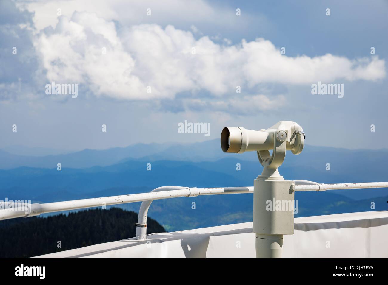 A modern metal orbital telescope of white color on a high observation