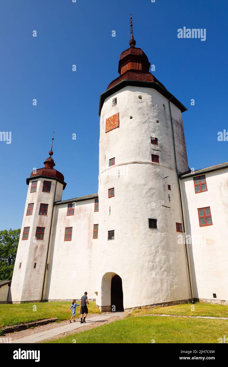 Lacko, Sweden - June 23, 2020: An adult and a child visit the medieval Lacko castle through the main gate. The construction of Lacko castle began duri Stock Photo