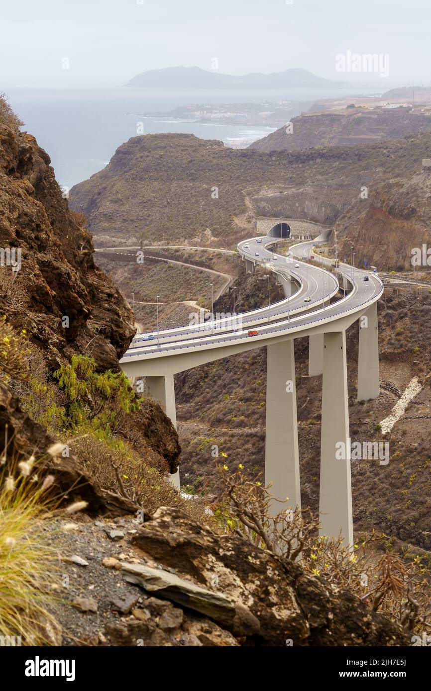 road over huge bridge bordering the mountains by the sea on the island of Gran Canaria. Spain Stock Photo