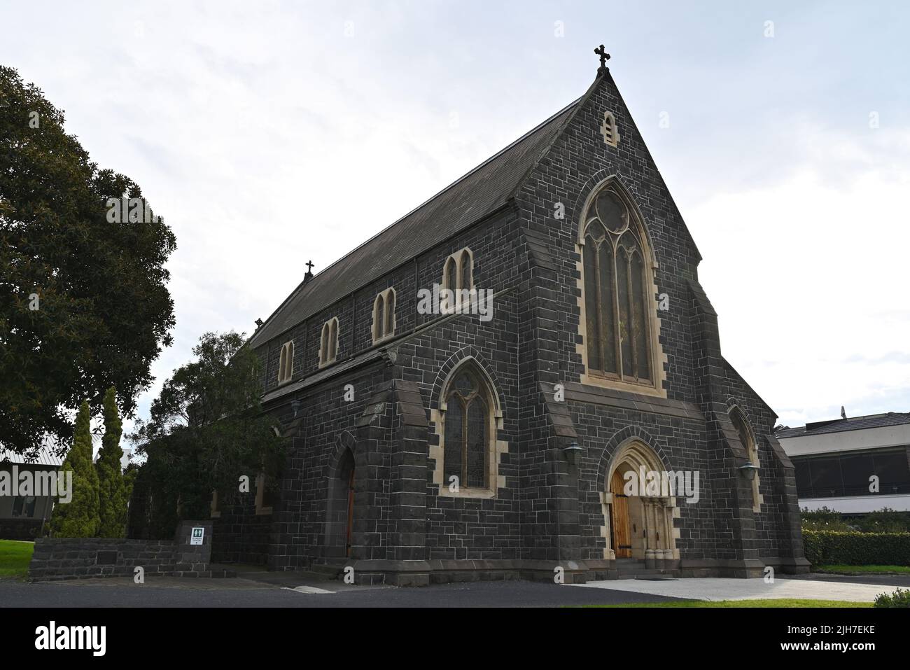 Exterior of Holy Trinity Anglican Church, predominantly made of bluestone, during an overcast day Stock Photo