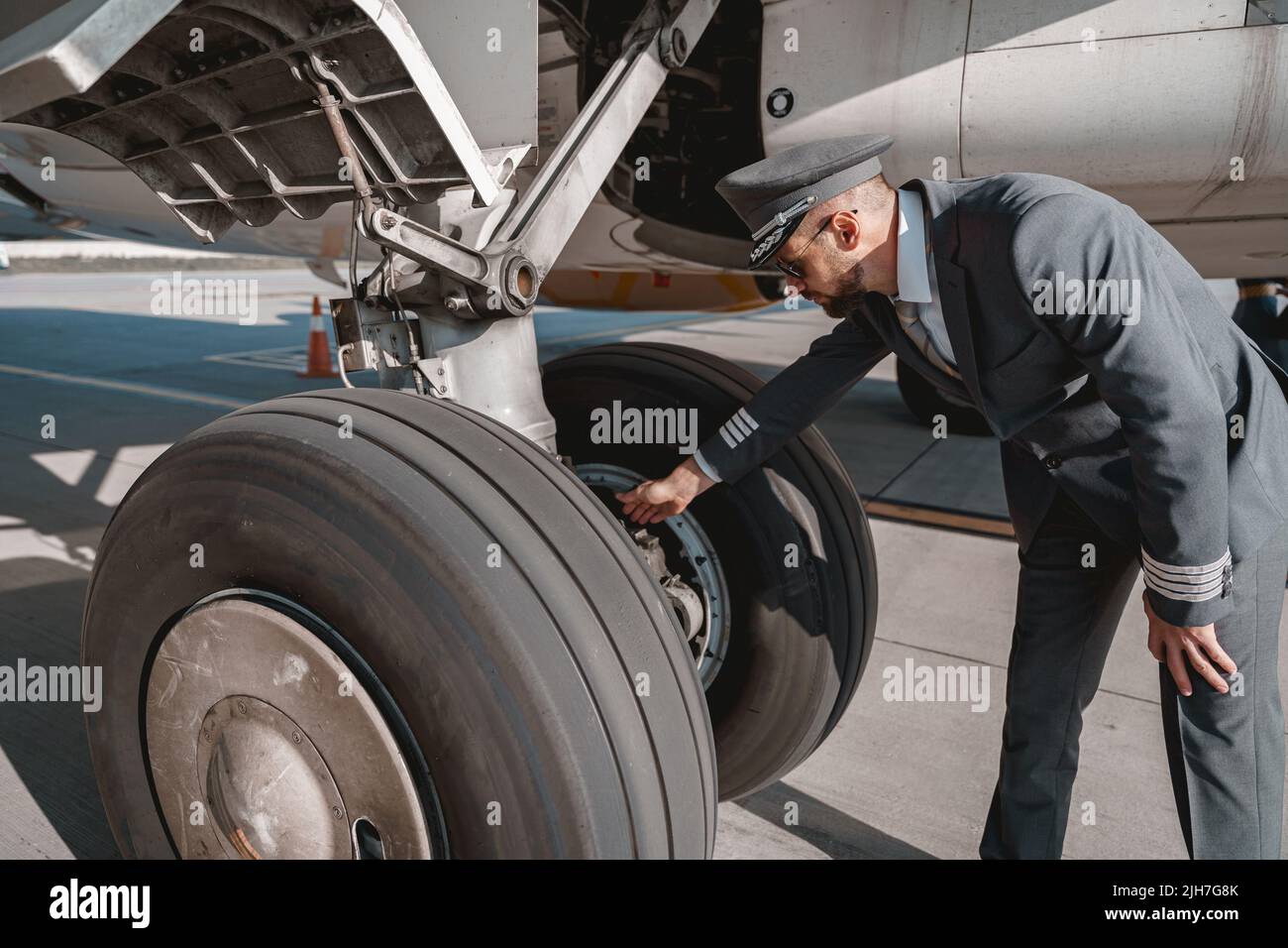 Pilot in uniform checks the aircraft before the flight in airport Stock