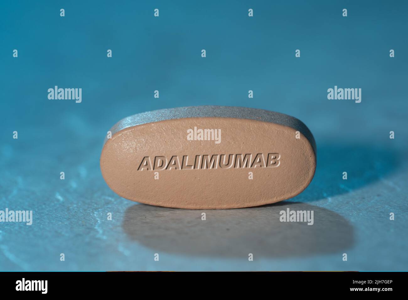 Adalimumab drug Pill Medication ob blue background Stock Photo