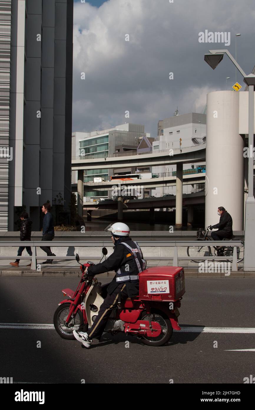 A Japanese postman on a moped.  Nihonbashi, Tokyo, Japan Stock Photo