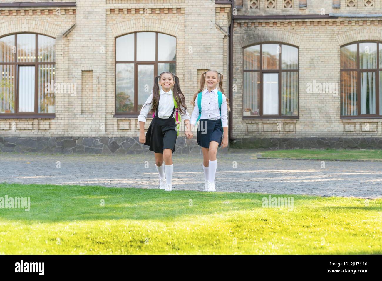 two teen girls in uniform walking together outdoor Stock Photo - Alamy