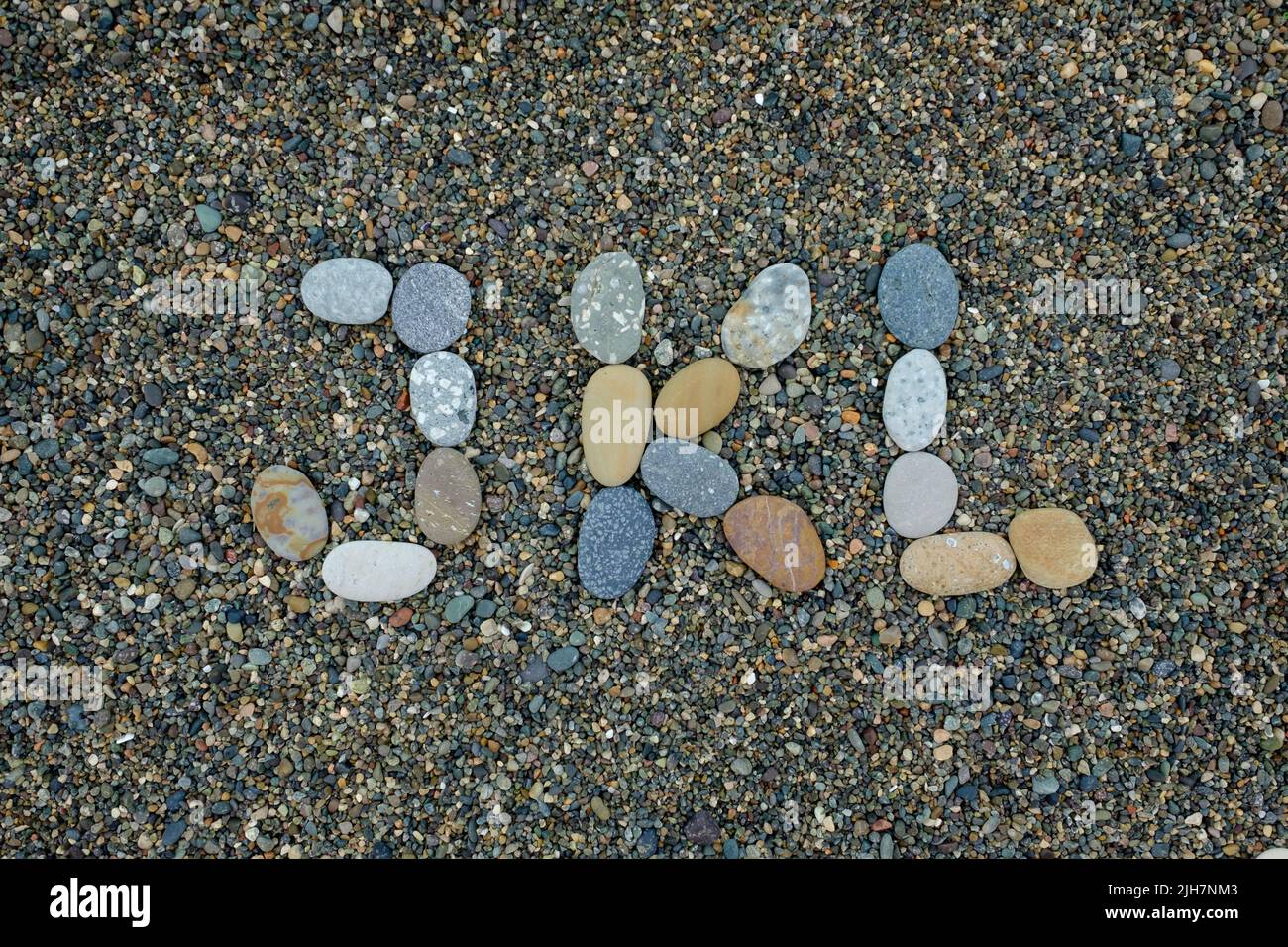 letters j k l made from stones in sand on beach Stock Photo