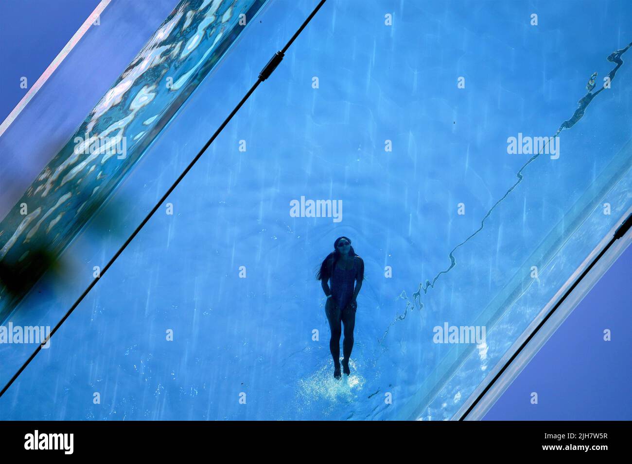 A woman swims in the Sky Pool, a transparent swimming pool suspended 35 ...