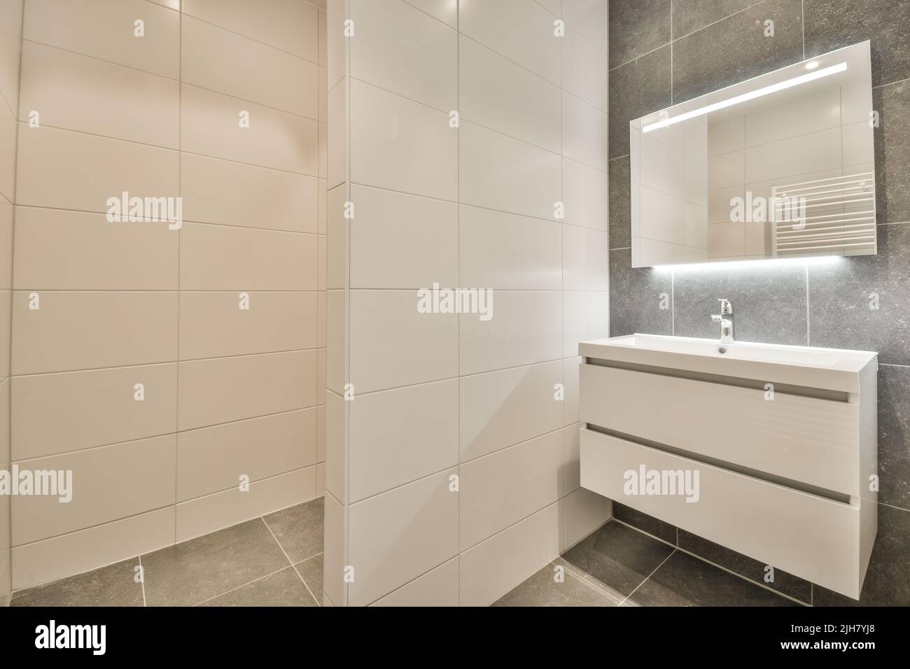 Glass partition between shower tap and wall hung toilet in modern