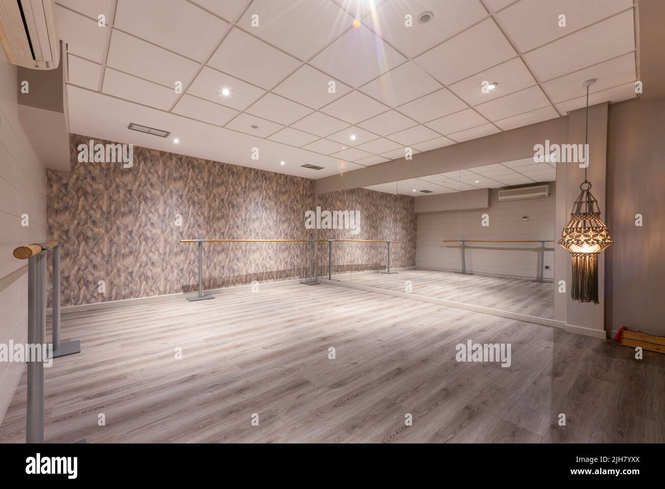 dance workout room with a mirror covered wall and wooden walkways with