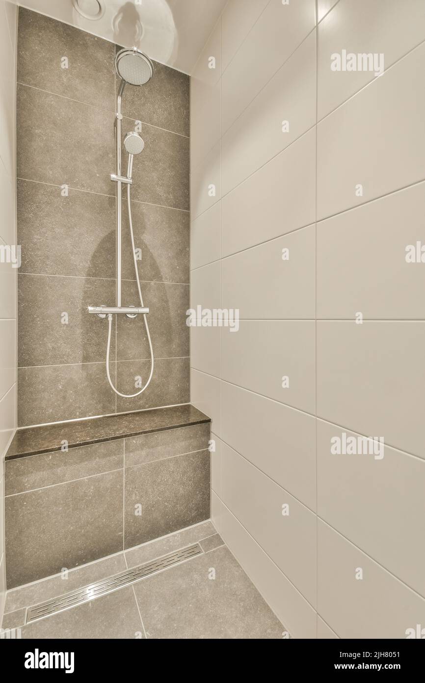 Glass partition between shower tap and wall hung toilet in modern