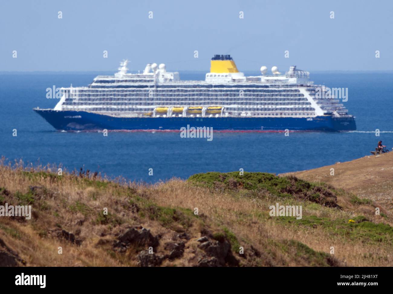 Newquay, UK. 16th July, 2022. UK Weather A very rare sail past from a cruise ship on North Cornwall’s rugged north coast. The Spirit of Adventure with 1000 passengers and over 500 crew members is en route from Belfast to Breast in France. Visitors and locals watch from East Pentire Headland and The Lewannick lodge hotel as the spectacle passes. As no suitable ports are available for large ships on this coast, visits are rare. 16th July 2022.      Robert Taylor Alamy Live News Credit: Robert Taylor/Alamy Live News Stock Photo