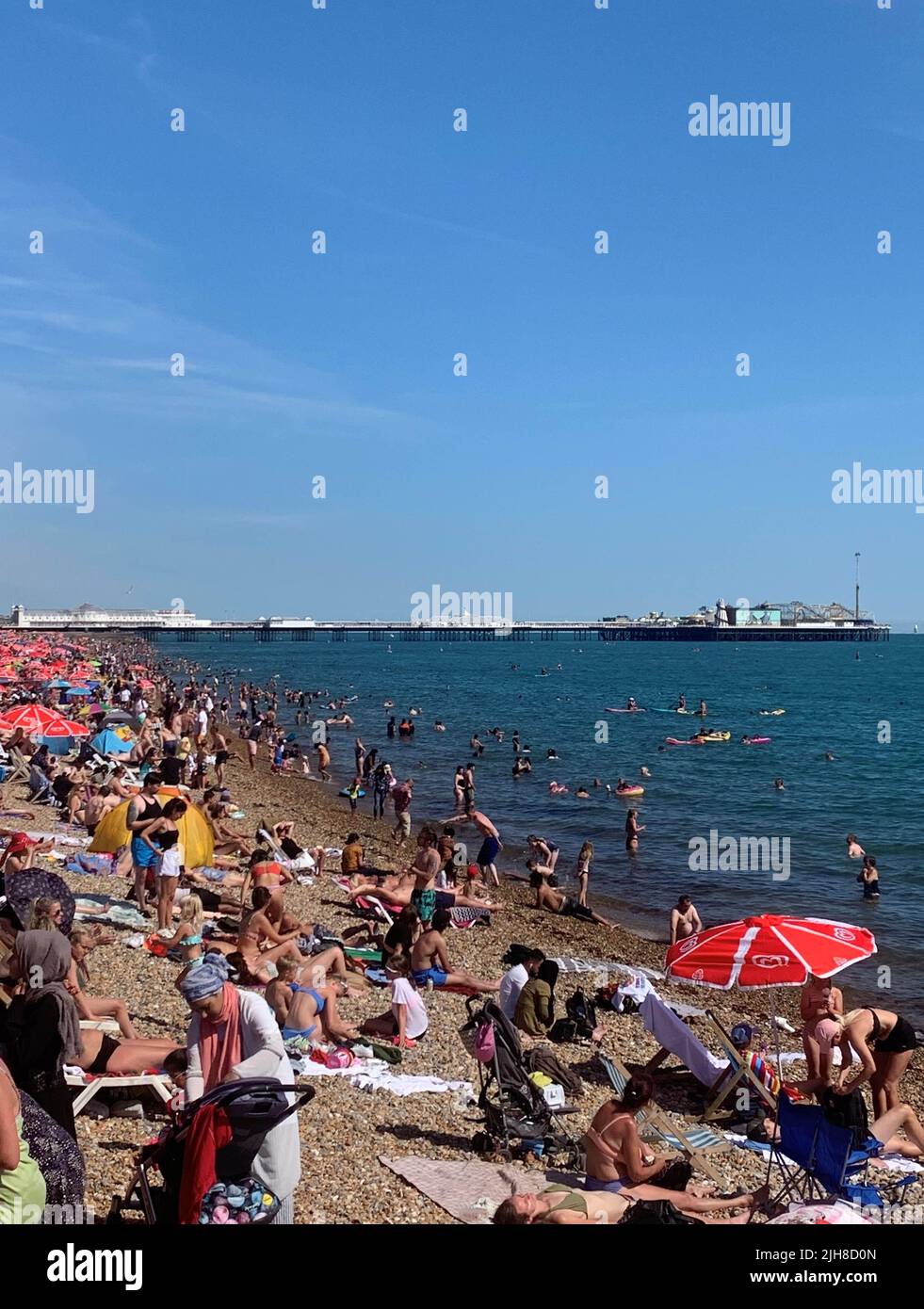 Crowds enjoy the hot weather at Brighton beach in Sussex, as