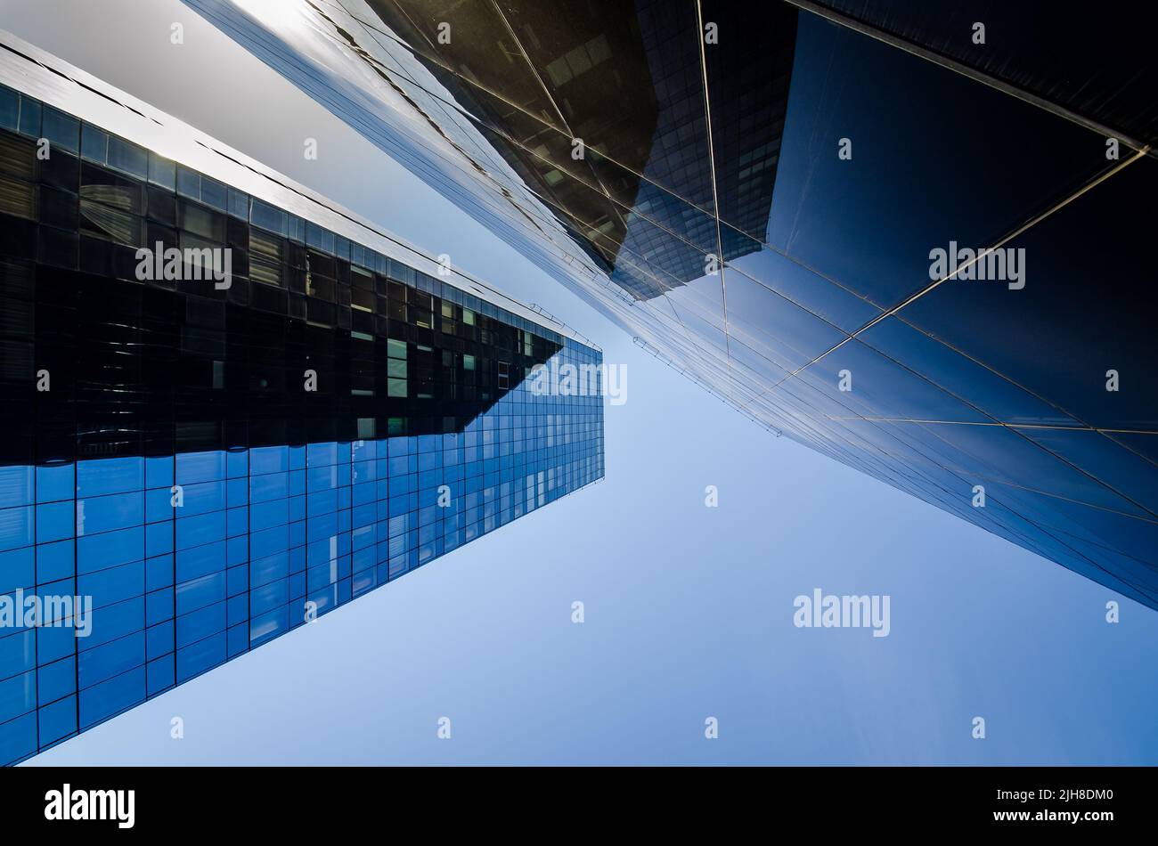 A modern skyscrapers whose glass facade is reflected by the blue sky ...