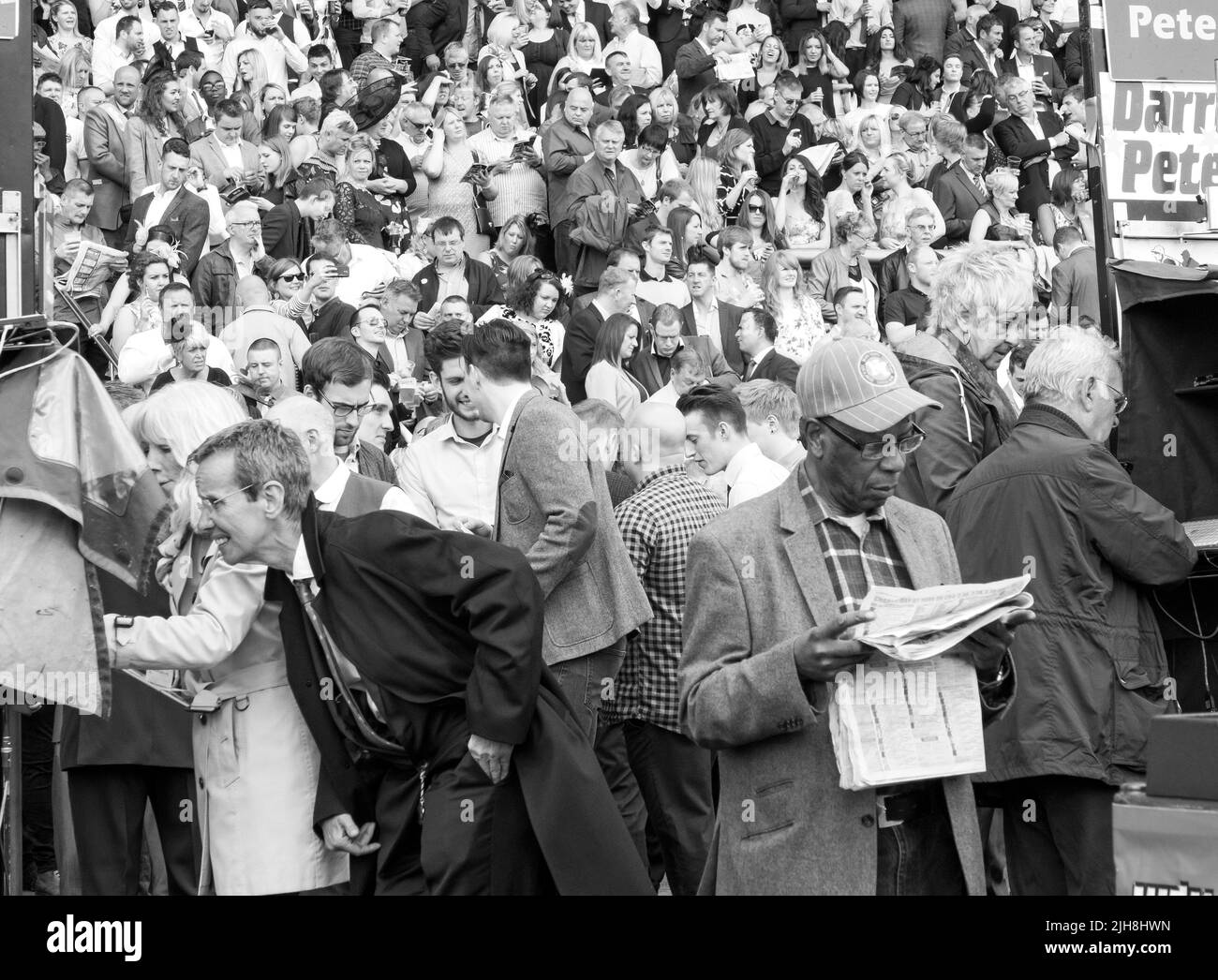 A grayscale shot of people gathered at Chester races enjoying their free time Stock Photo
