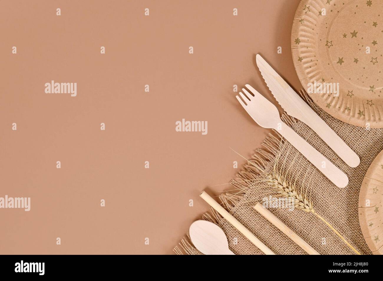 Eco friendly paper party plates and wooden cutlery in corner of beige background with copy space Stock Photo