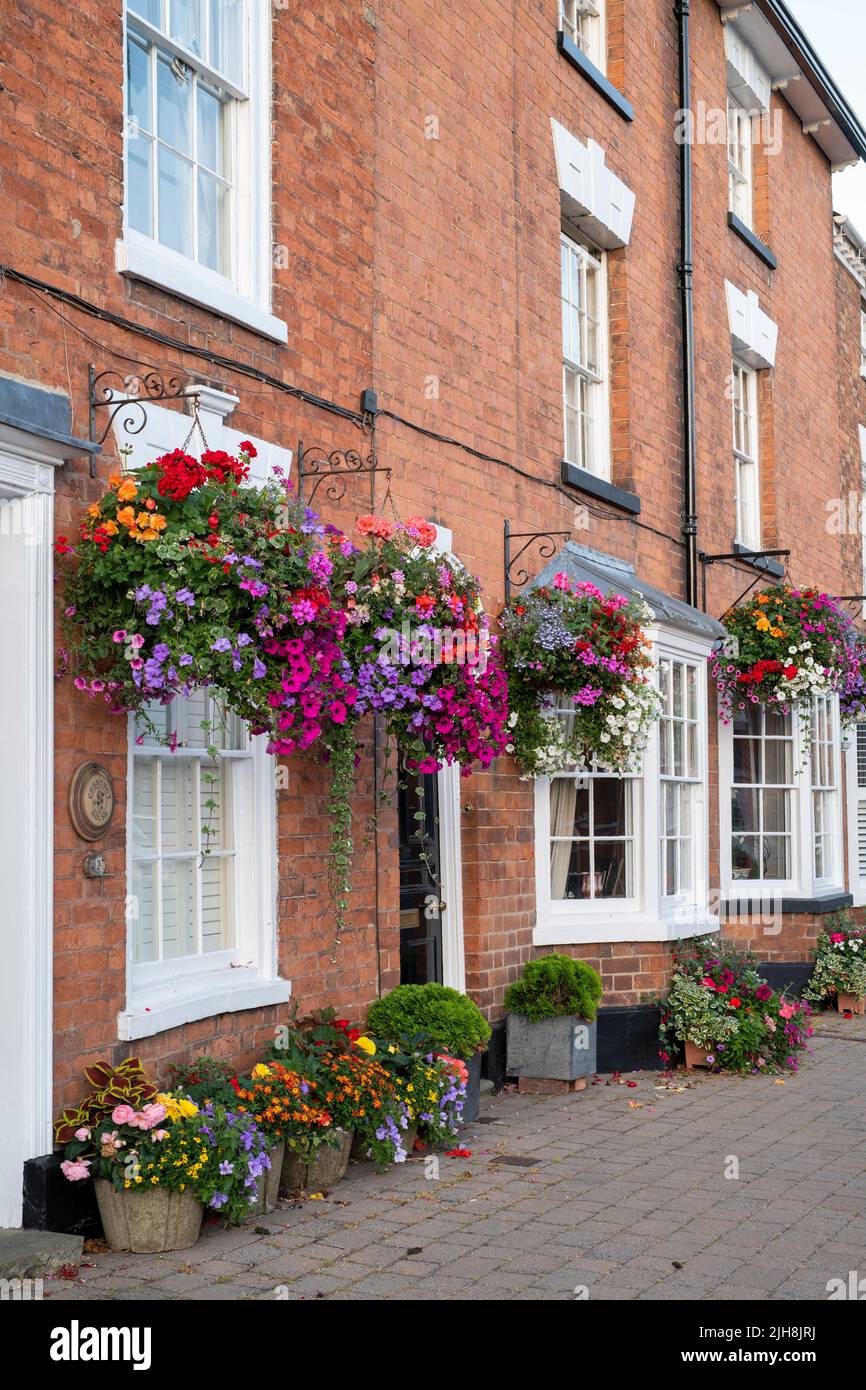 Hanging baskets of flowers on house fronts in the town of Pershore