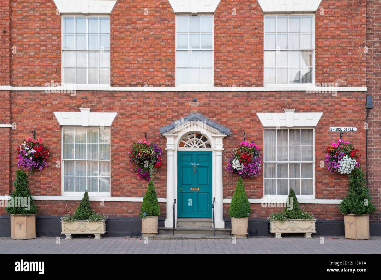 Hanging baskets of flowers on a house exterior in the town of Pershore, Worcestershire, UK Stock Photo