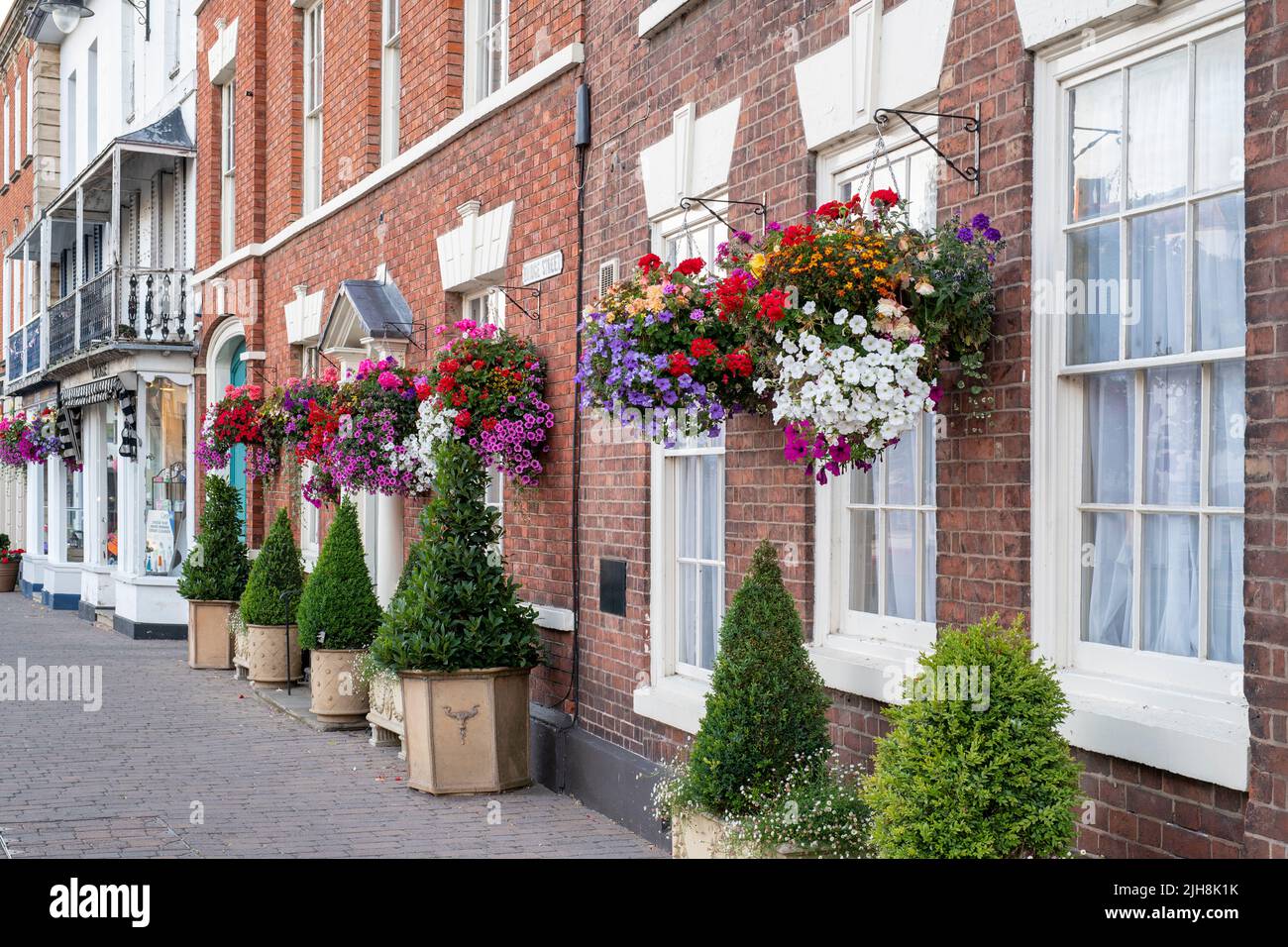 Hanging baskets of flowers on house fronts in the town of Pershore, Worcestershire, UK Stock Photo