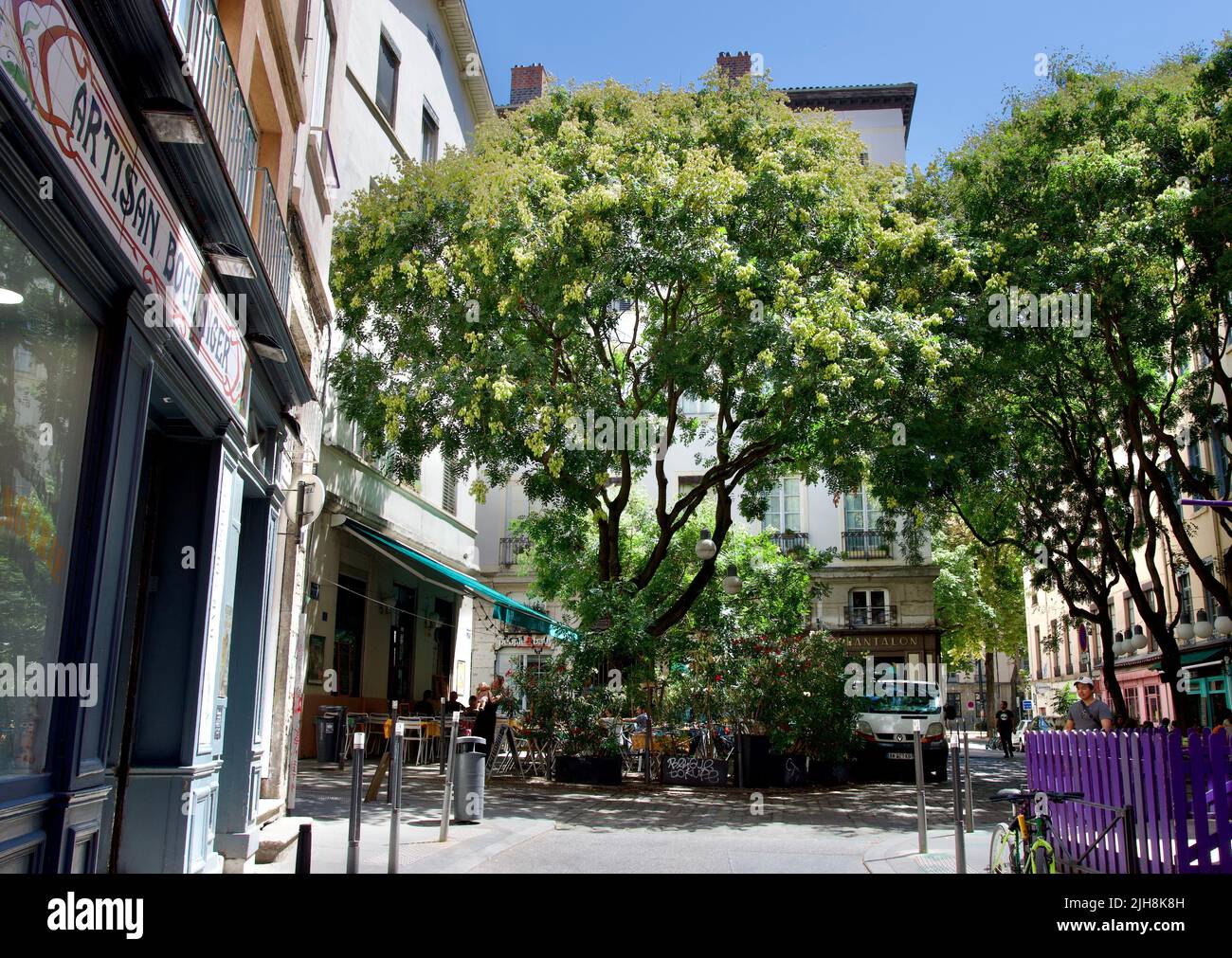 Beautiful Fernand Rey square in full sun with its flowers, trees and restaurant terraces at the foot of the slopes of La Croix Rousse in Lyon, France Stock Photo