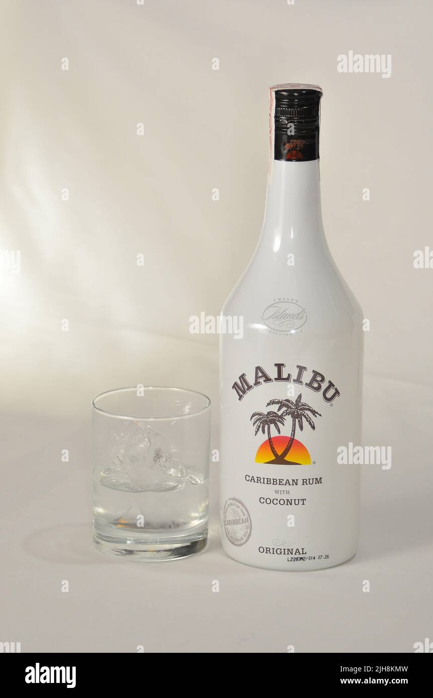 A vertical shot of a bottle of Malibu rum and a glass cup in a studio Stock Photo