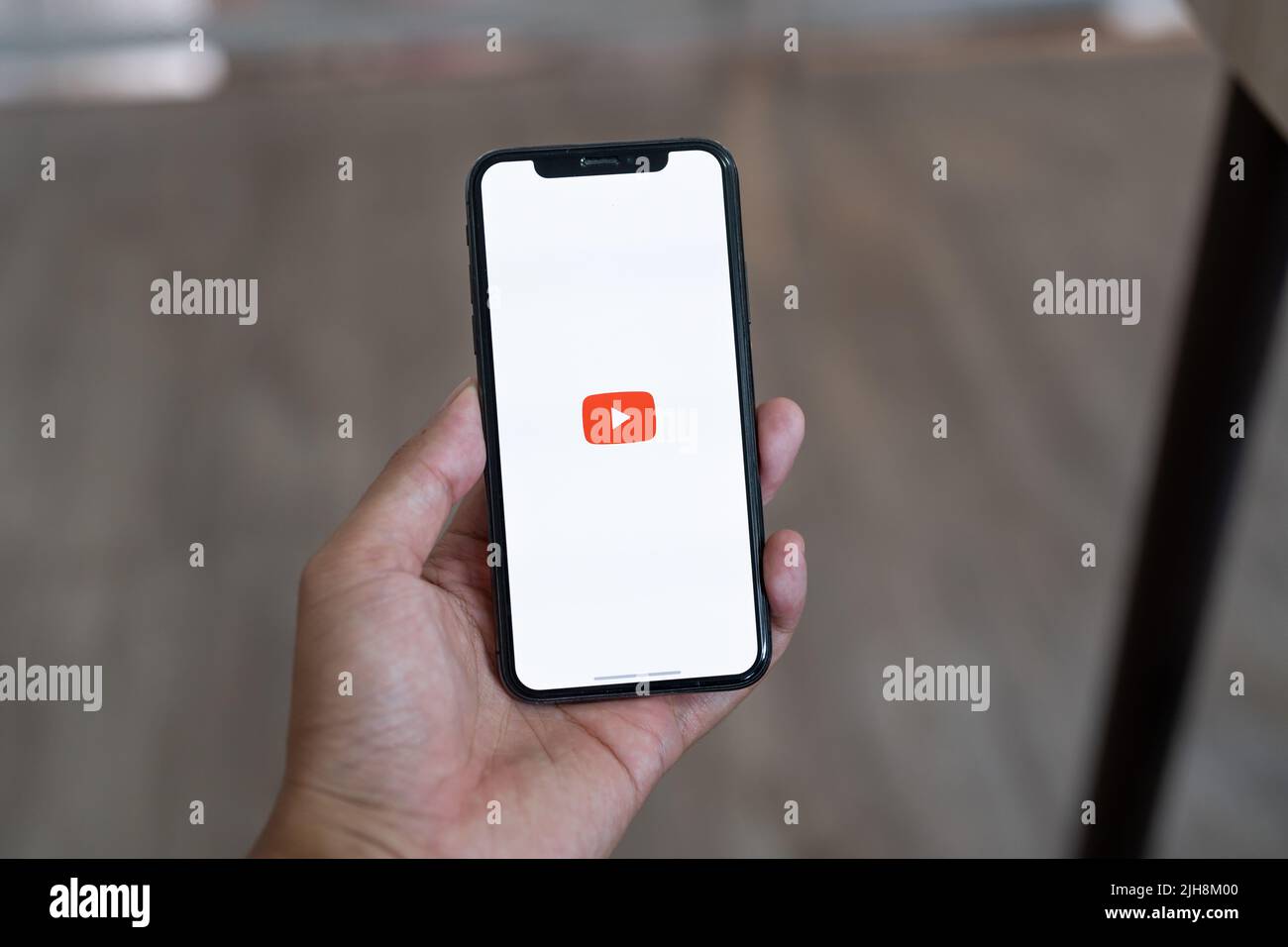 CHIANG MAI, THAILAND, JUL 12, 2022 : Woman hand holding Apple iPhone X with App YouTube provides streaming media and video on the screen. Stock Photo