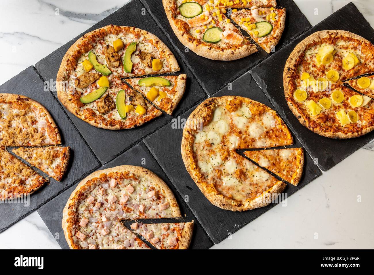 A set of different California-style nontraditional pizzas on black serving plates Stock Photo