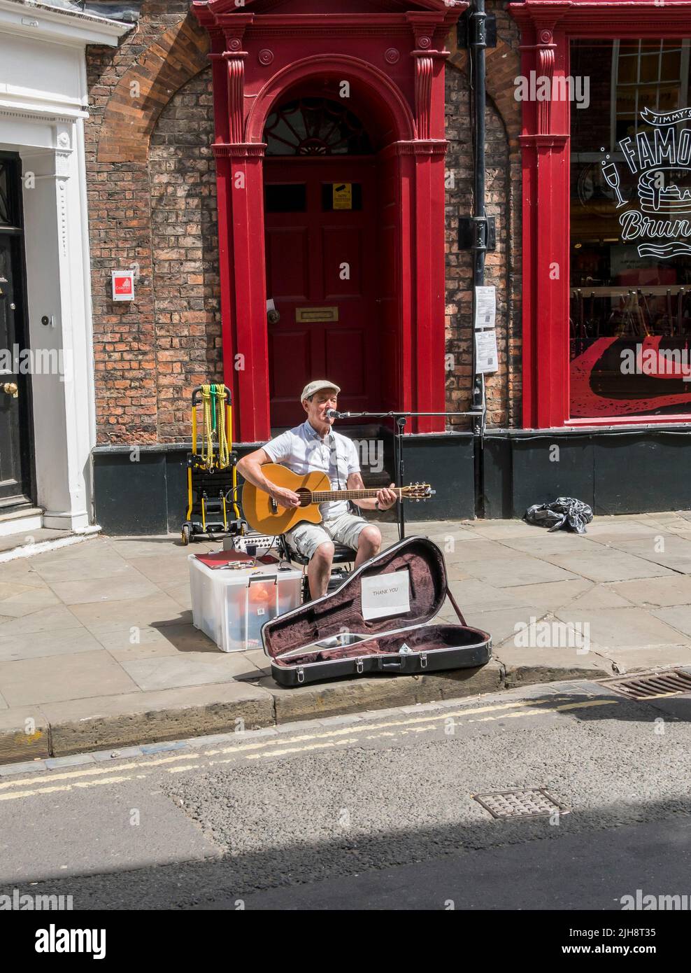 Street performer vocalising to guitar accompaniment petergate York city 2022 Stock Photo
